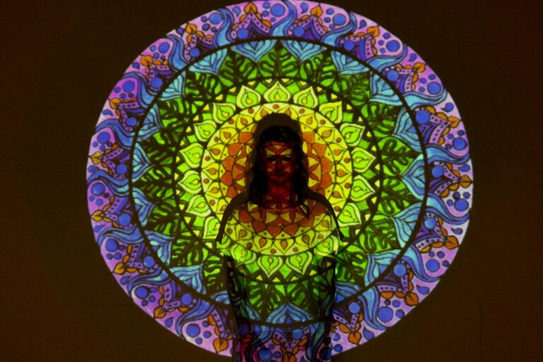 Vibrant mandala projected onto person, creating a fusion of colors and shapes.